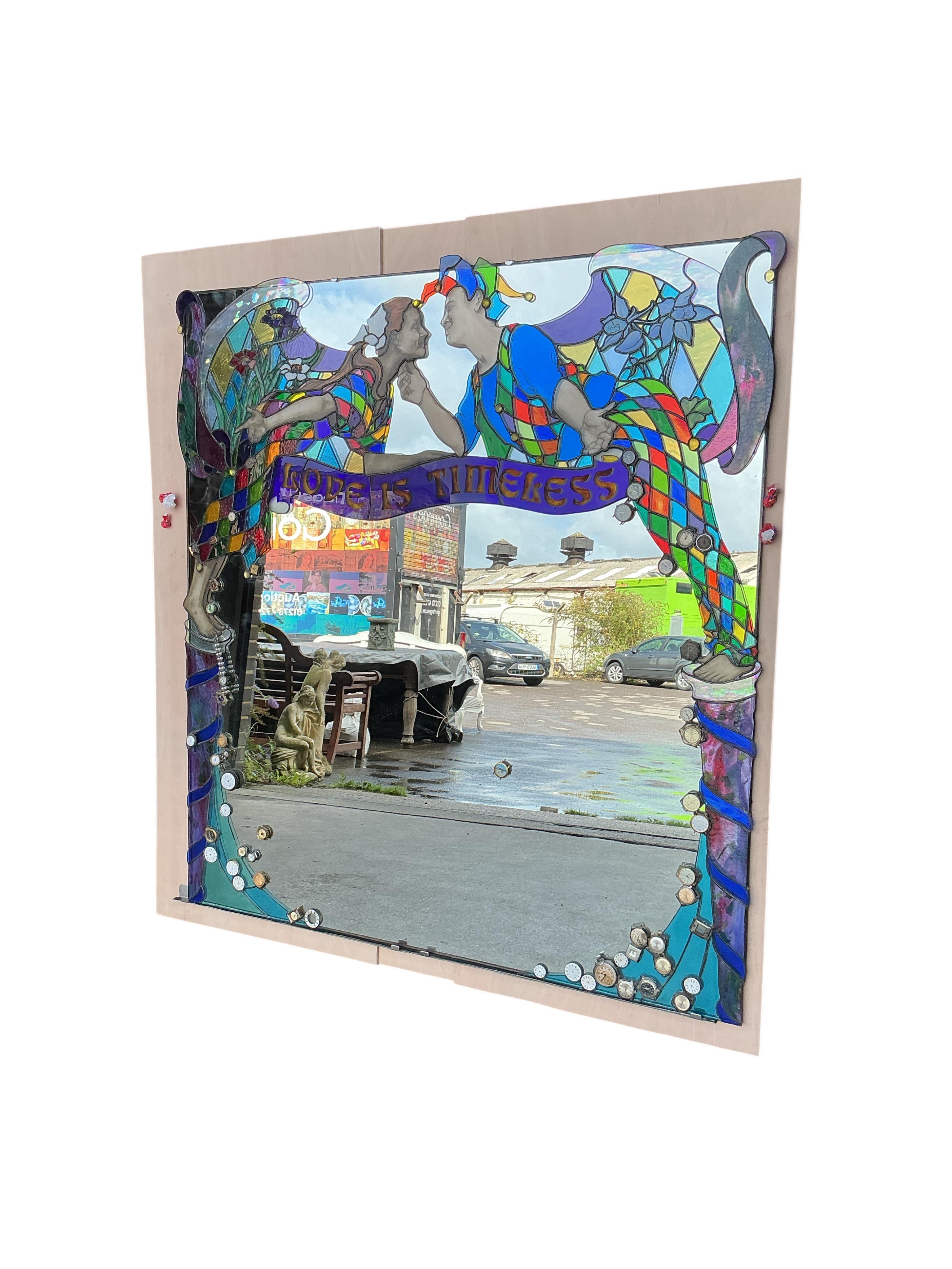 A Contemporary stained glass overmantel mirror “Love is Timeless” by Brighton artist Annelies Clark, the plate inset assorted wristwatch heads, width 128cm, height 138cm